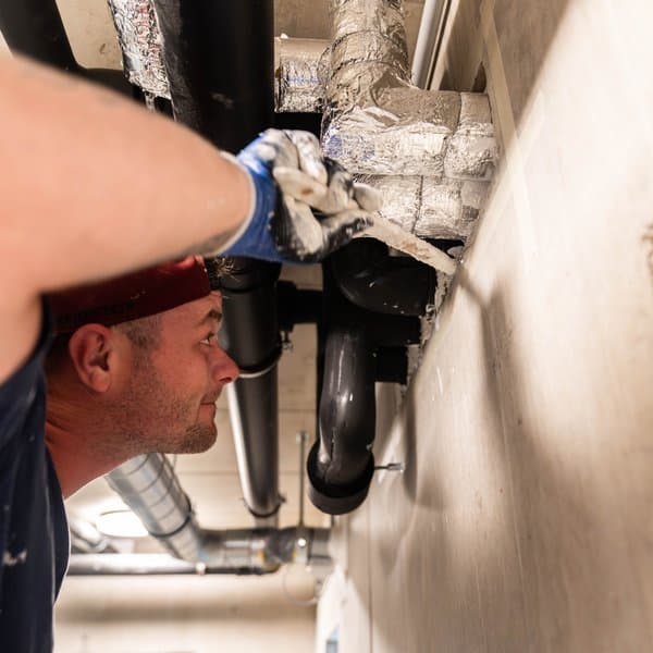 Monteur von Preventos dichtet eine isolierte Leitung an der Wand ab