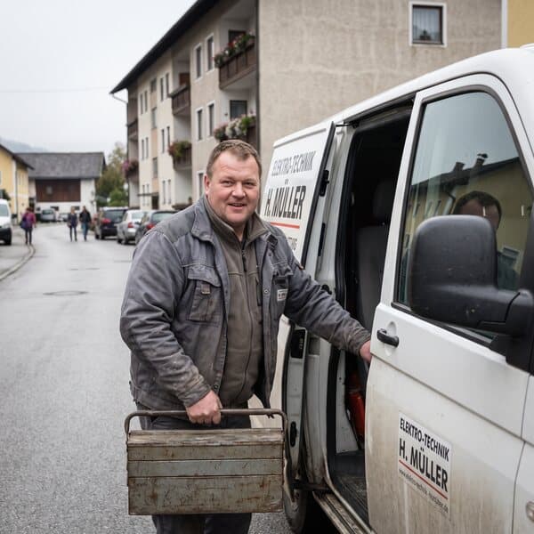 Servicetechniker holt einen Werkzeugkoffer aus dem Firmenwagen