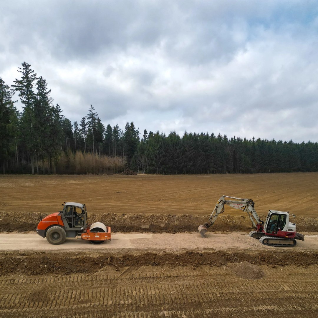Walze und Bagger von Klaus Stockinger bei Erdarbeiten auf einem Feld